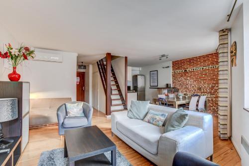 a living room with a couch and a table at Duplex Tolosa - Pont-Neuf, Dôme de la Grave, 2 BDRs 85m2, AC, Free private car park 200m away - T3 85m2 avec clim, parking couvert gratuit à 200m in Toulouse