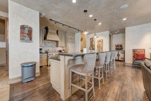 a kitchen with a bar with bar stools at Vintage on the Strand by All Seasons Resort Lodging in Park City