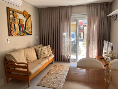 - un salon avec un canapé et une table dans l'établissement Residencial Casa Flora - Centro de Bombinhas SC, à Bombinhas