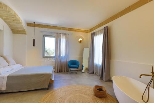 Schlafzimmer mit einem Bett, einer Badewanne und einem Waschbecken in der Unterkunft Petra - Sud Est Charme in Andrano