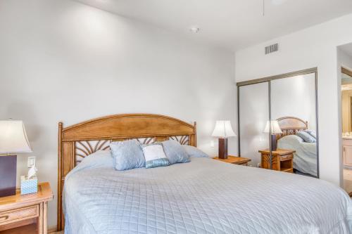 a bedroom with a large bed with blue pillows at Waikoloa Fairways C119 in Waikoloa Village