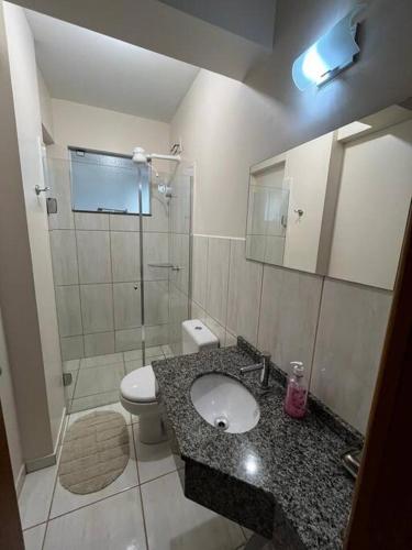 a bathroom with a sink and a toilet and a shower at Apto Aconchegante Central! 23 in Toledo