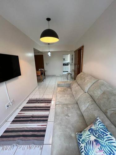 a living room with a couch and a flat screen tv at Apto Aconchegante Central! 23 in Toledo