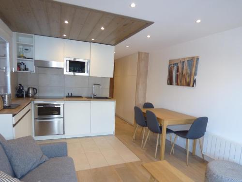 une cuisine et une salle à manger avec une table et des chaises dans l'établissement Charmant 2 pièces au centre de Méribel avec balcon et WiFi - FR-1-411-872, à Les Allues