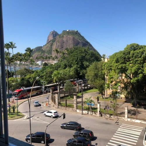 a street with cars parked in a parking lot with a mountain at Melhor Localização! Botafogo-URCA in Rio de Janeiro
