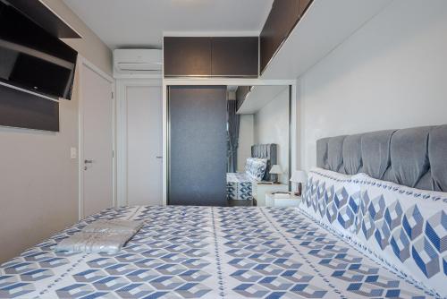sypialnia z łóżkiem z niebiesko-białą narzutą w obiekcie LUXO E VISTA ESPETACULAR para São Paulo com PISCINA ACADEMIA e SAUNA w São Paulo