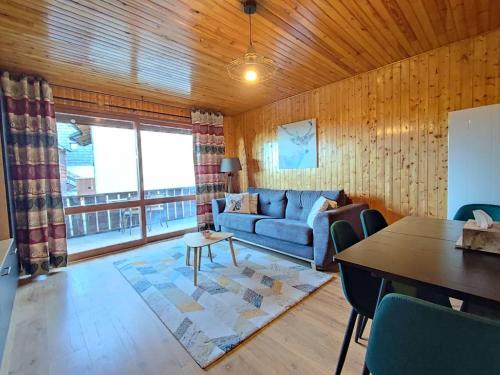 salon z niebieską kanapą i stołem w obiekcie Appartement rénové 3 pièces cabine, 50m des pistes, 8 couchages, balcon SUD, Wifi, TV - FR-1-592-54 w mieście Bolquere Pyrenees 2000