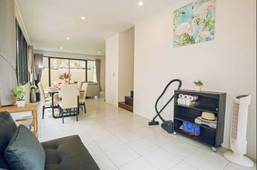 a living room with a couch and a dining room at Enjoy Samui Residences Pause by Replay in Koh Samui 