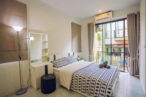 a bedroom with a bed with a teddy bear sitting on it at Enjoy Samui Residences Pause by Replay in Koh Samui 
