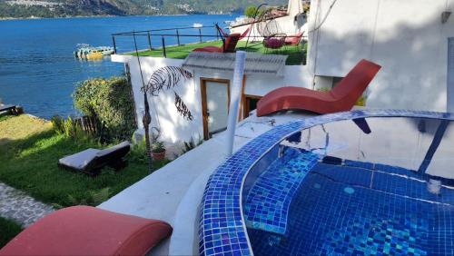 a house with a swimming pool next to the water at TIBERIAS by luxury Atitlan in San Pedro La Laguna