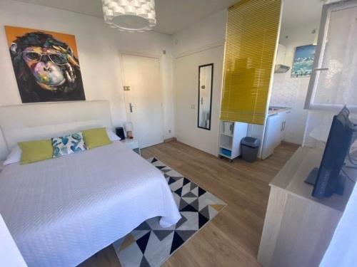 sypialnia z białym łóżkiem i obrazem na ścianie w obiekcie Studio Centre-Ville avec Terrasse, Équipé, Lumineux - FR-1-703-8 w mieście Amélie-les-Bains-Palalda