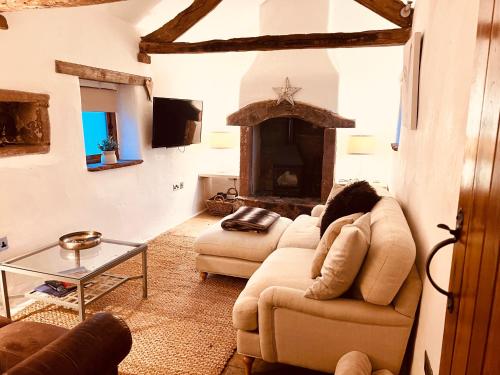 a living room with two couches and a fireplace at The Nook Cottage in Carlisle