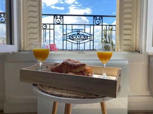 ein Tablett mit Essen und zwei Gläser Orangensaft in der Unterkunft Petit Cosy Aux Portes de Paris, En Face Du M 13 in Asnières-sur-Seine