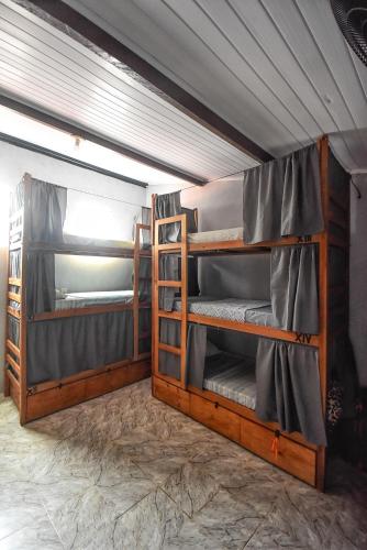a bunk bed with three bunk beds in a room at Hostel Rota Itacaré in Itacaré