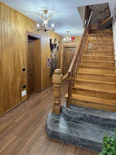a staircase in a home with wooden walls and wooden floors at Hotel Ambassador Voskopojë in Voskopojë