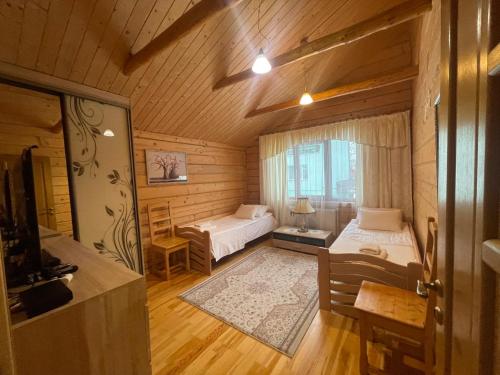 1 dormitorio con 2 camas y TV en una habitación en Зелена садиба над рікою, en Slavske