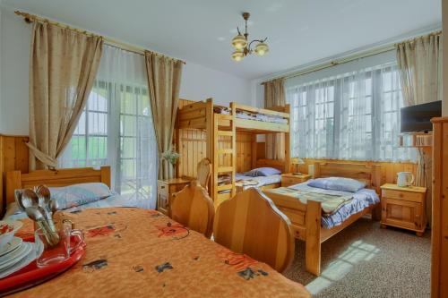 a bedroom with two beds and a bunk bed at Dom Wypoczynkowy Pokusa in Tylicz