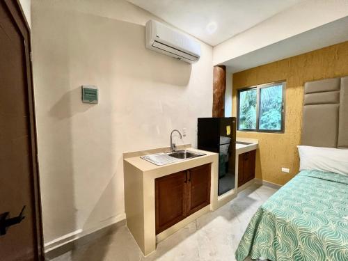 a bathroom with a sink and a bed at Suites Valentina in Puerto Morelos