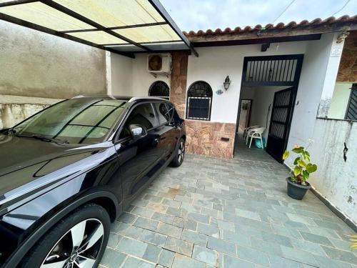 a car parked in front of a house at Aconchegante casa a 50m da praia in Praia Grande