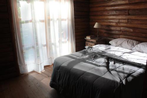 - une chambre avec un lit et un mur en bois dans l'établissement Cabaña Inti Mampa, à Casa Grande