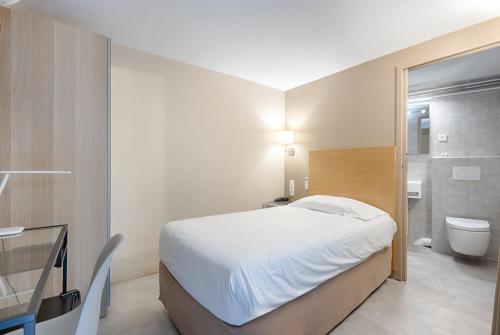 een slaapkamer met een bed en een badkamer met een toilet bij Marmotel Etoile in Parijs