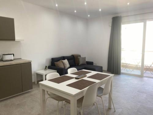 een woonkamer met een tafel en een bank bij Sandstone Apartment 17 in Marsaskala
