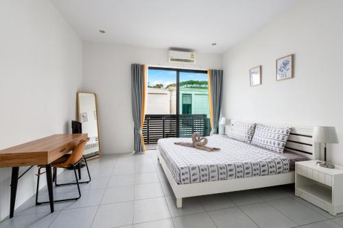 a bedroom with a bed and a desk and a table at Enjoy Samui Residences Pause by Replay in Koh Samui 