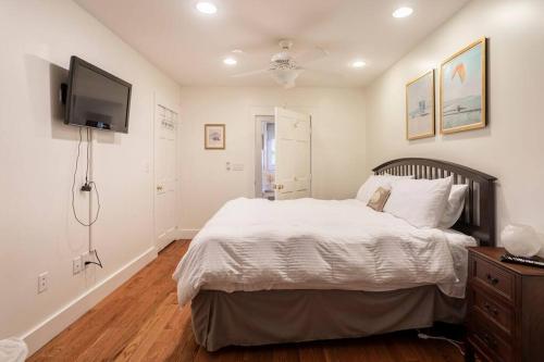 a bedroom with a large bed and a flat screen tv at Spacious Oceanview Villa (Sleeps 22) in New London