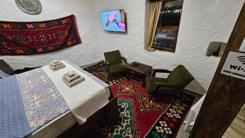 Cette chambre comprend une table, des chaises et un tapis. dans l'établissement Old Mill apartment, à Mostar