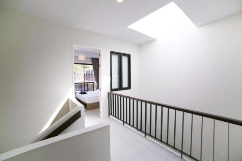 a hallway with white walls and a stair case at Enjoy Samui Residences Pause by Replay in Koh Samui 