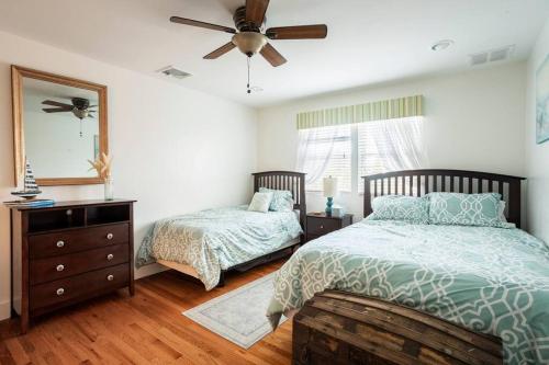 a bedroom with two beds and a ceiling fan at Spacious Oceanview Villa (Sleeps 22) in New London