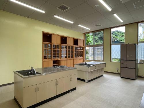 a large kitchen with two sinks and cabinets and windows at LivingAnywhere Commons Uruma Male Dormitory bunk bed - Vacation STAY 15526v in Uruma