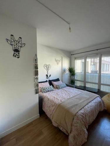 une chambre avec un grand lit et une fenêtre dans l'établissement Résidence Carnot, à Alfortville