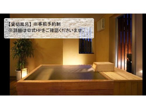 una vasca in legno in una stanza con un cartello di Hotel Kimura - Vacation STAY 97364v a Shibukawa