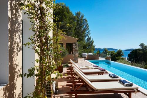 a villa with a swimming pool and lounge chairs at Villa Zinnia in Skiathos Town
