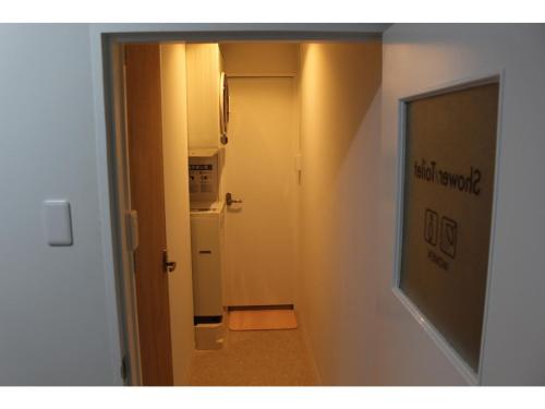 a hallway with a door leading to a room with a refrigerator at Guesthouse Banvina - Vacation STAY 03952v in Kagoshima