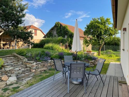 a patio with a table and chairs and an umbrella at Domek v Podyjí in Lukov