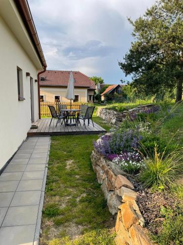 a patio with a table and chairs in a yard at Domek v Podyjí in Lukov