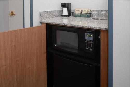 a black microwave oven sitting under a kitchen counter at Courtyard by Marriott Cypress Anaheim / Orange County in Cypress