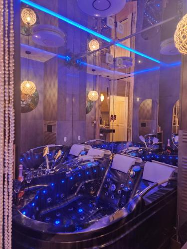 a dining room with blue lighting and a bar at WARSZAWA WOLA Wyjątkowe Studio z Jacuzzi, Sauną i Fotelem do Masażu - Exceptional Studio in Warsaw with Jacuzzi, Sauna and Massage Chair in Warsaw