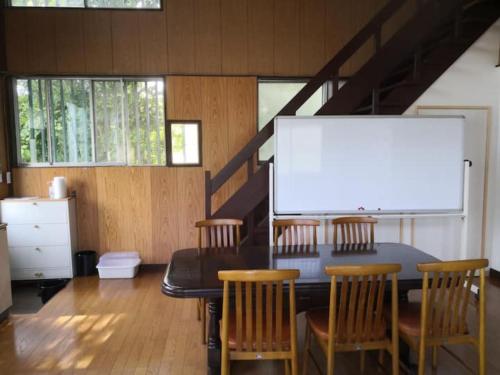伊豆市にあるBouldering & SPA -Ariki Resort Shuzenji ANNEX- - Vacation STAY 07698vのテーブル、椅子、ホワイトボードが備わる客室です。