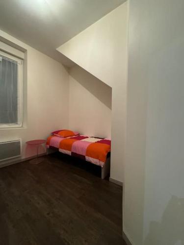 une chambre avec un lit dans une pièce blanche dans l'établissement Christelle, à Romilly-sur-Seine