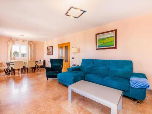 uma sala de estar com um sofá azul e cadeiras em Belvilla by OYO Villa Malen s Mallorca em Llucmajor