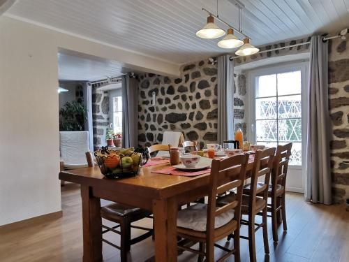 une salle à manger avec une table et des chaises en bois dans l'établissement Location au cœur du Devès, proche Puy-en-Velay et chemin de St-Jacques - FR-1-582-447, à Bains