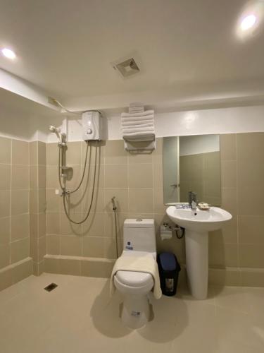 a bathroom with a shower and a toilet and a sink at El Puerto Boracay Shore in Boracay