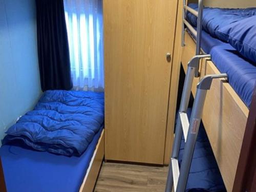 Cette chambre comprend 2 lits superposés et une couverture bleue. dans l'établissement Chalet Recreatiepark Duinhoeve 1, à Udenhout