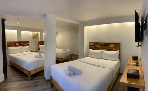1 dormitorio con 2 camas con sábanas blancas en El Puerto Boracay Shore en Boracay