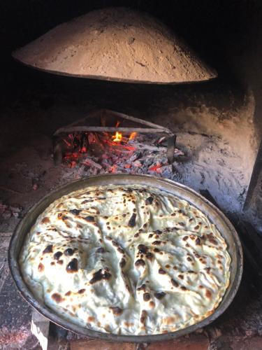 a pizza is being cooked in an oven at Hotel Ambassador Voskopojë in Voskopojë