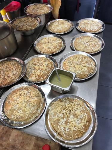 a bunch of pans of food on a table at Hotel Ambassador Voskopojë in Voskopojë