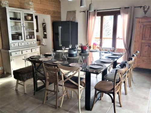 une cuisine avec une table avec des chaises et un réfrigérateur dans l'établissement Chalet cosy 4* à 100m des pistes, avec sauna, WIFI et parking privé - FR-1-267-269, à Villarembert